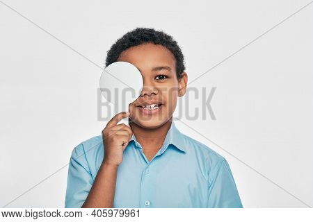 African American Male Kid Having Eye Exam With One Eye Covering Using An Ophthalmic Tool, On White B
