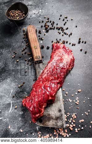 Raw Strip Vegas Steak On A Meat Cleaver. Black Background. Top View