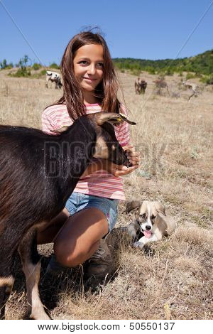 Cattle shepherd girl feeding a goat in the Bulgarian mountains