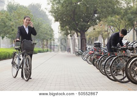 Young Business people parking their bikes and talking on the phone in Beijing