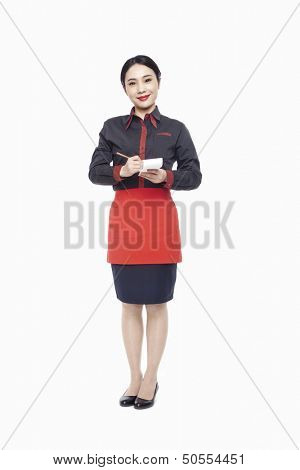 Young Waitress writing order on note pad, smiling, studio shot