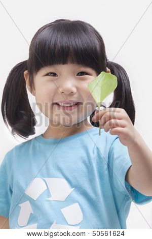 Little girl holding leaf, close up studio shot