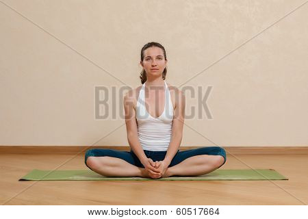 Caucasian Woman Is Practicing Yoga At Studio (baddha Kohasana)
