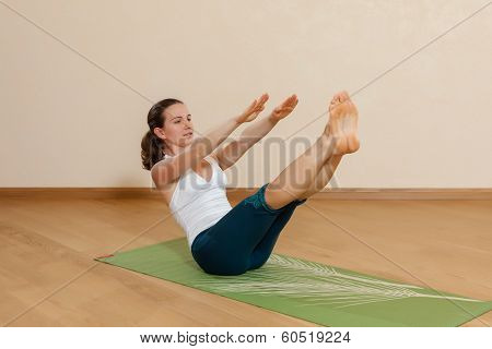 Caucasian Woman Is Practicing Yoga At Studio (paripurna Navasana)