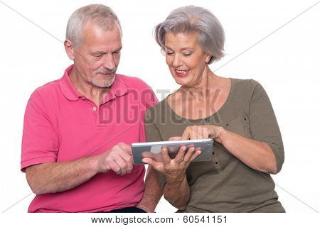 Senior couple with tablet computer in front of white background