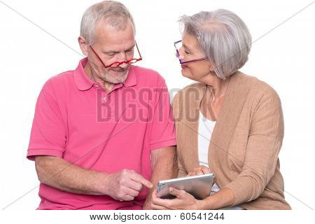 Senior couple with tablet computer in front of white background