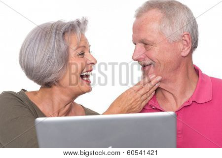 Senior couple with computer in front of white background