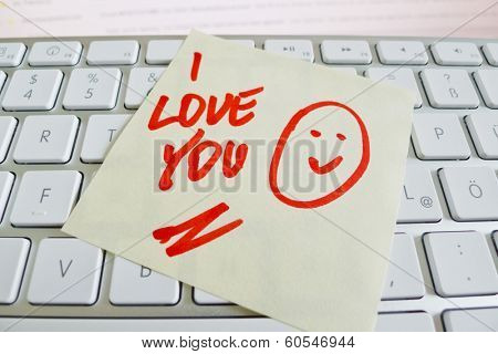 a sticky note is on the keyboard of a computer as a reminder: i love you