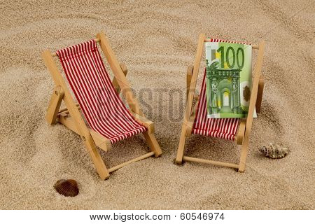beach chair with euro currency on the sandy beach. symbolic photo for travel costs, vacation, holiday