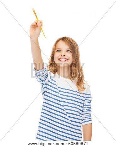 education, school and imaginary screen concept - cute little girl drawing with brush in the air or imaginary screen