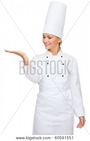 cooking, advertisement and food concept - smiling female chef holding something on palm of hand