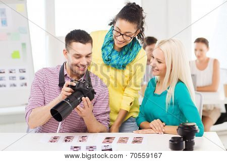 business, education, photography, office and startup concept - smiling creative team with photocamera working in office