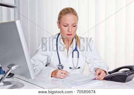 a young doctor with stethoscope in her doctor's office.