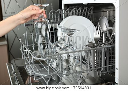 Open dishwasher with clean utensils in it