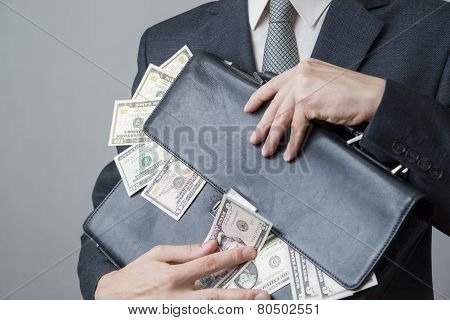 Businessman With A Briefcase Full Of Money In The Hands Of