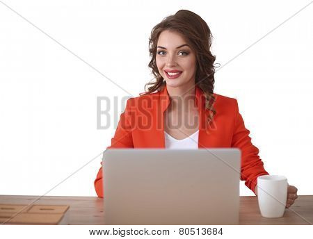 Attractive woman sitting at desk in office, working with laptop