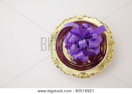 opening ceremony concept- purple ribbon bow on the golden plate