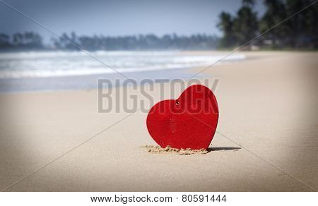Red heart on exotic sandy beach - Love concept