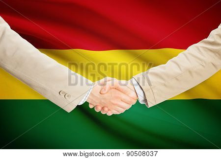 Businessmen Handshake With Flag On Background - Bolivia