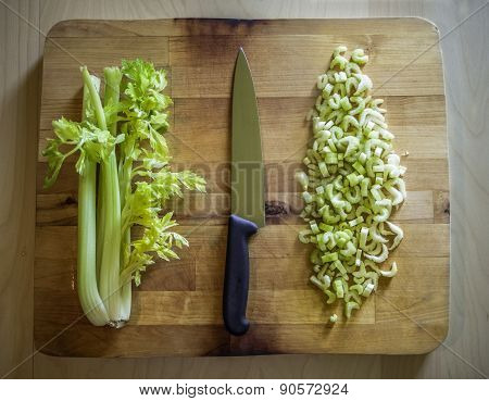 Cutted And Whole Celery On A Wooden Board With A Knife