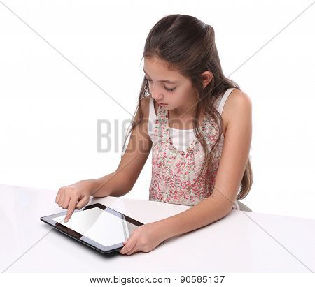 Beautiful pre-teen girl using a tablet computer. Isolated