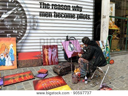 Street artist draws and sells paintings in Belgium