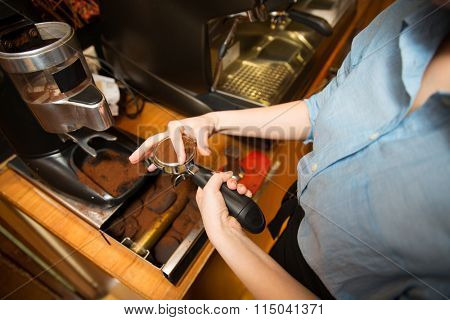 close up of woman making coffee by machine at cafe