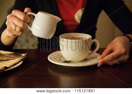 A Cup Of Coffee And A Jug In Girls Hands