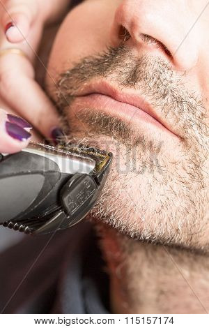 Hairdresser, cutting beard in her work place