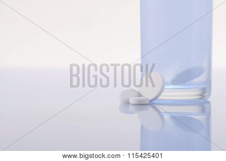 Pills and water in a glass.
