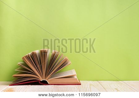 Open book on green wooden bavkground. Education background.