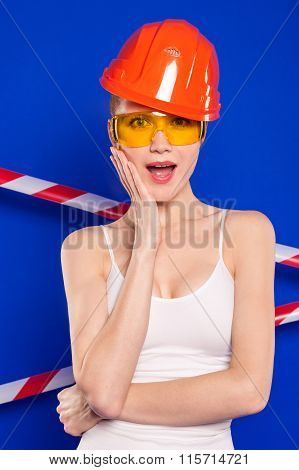 Blonde With Construction Helmet And Goggles On A Blue Background