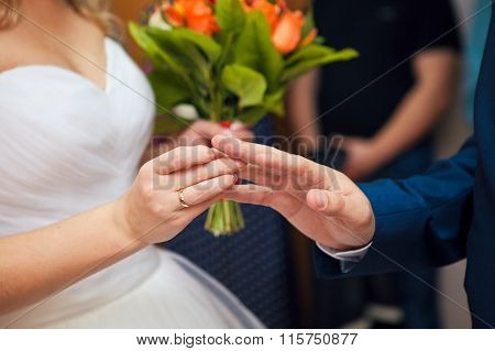 The bride and groom exchange rings at wedding ceremony