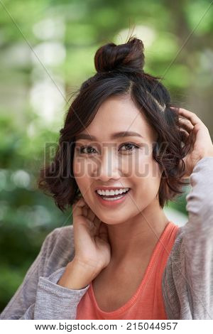 Portrait of joyful Vietnamse young woman looking at camera
