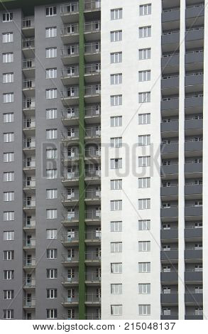 The facade of a typical block multi-storey residential building. Front view close up.