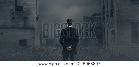 Businessman standing over apocalyptic background. Crisis, default, setback concept.