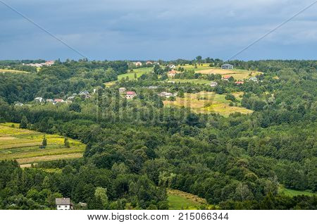 Summer rural landscape. Homes in the countryside among the green hills.