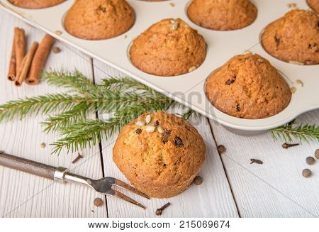 Christmas cupcakes with spices cloves, seeds and nuts in a baking dish on white wooden table