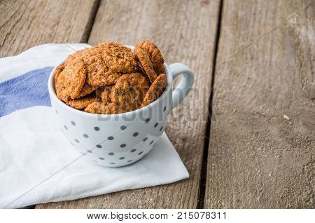 Chocolate cookies in coffee cup on the wooden table.