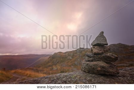 Zen balanced small pile of stacked stones on a walking path starting on top of Mount Ulriken in Bergen, Norway