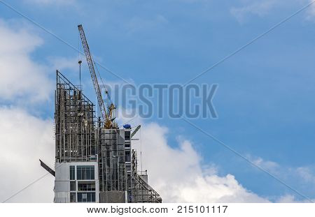 Crane working on top of building and sky on background