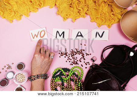 Man in women's jewelry puts the inscription on pink background