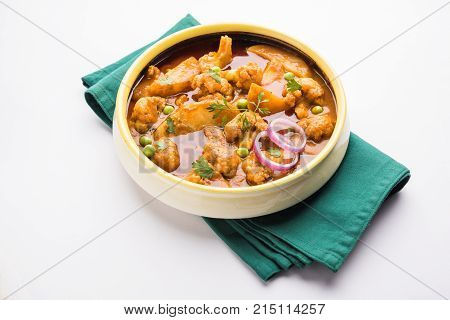 Aloo Gobi matar is a famous Indian curry dish with potatoes and cauliflower and green peas, selective focus