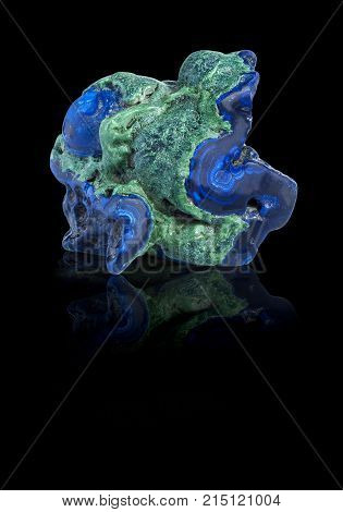 Blue and green Azurite gemstone with ground reflection on the black background