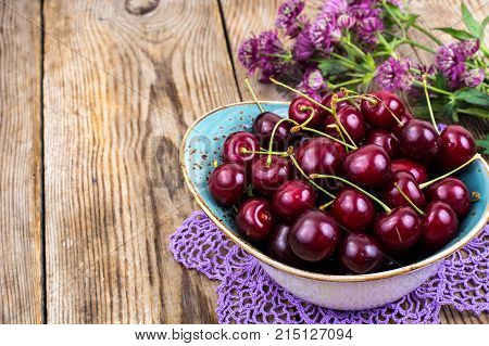 Mellow sweet cherry in bowl on wooden table. Studio Photo
