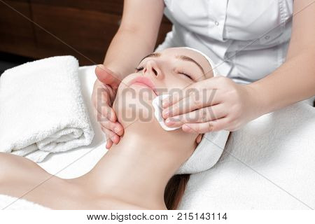 doctor beautician cleanses the skin woman with a sponge. Perfect cleaning - spa treatment skincare face.