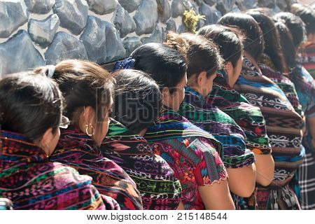 March 25, 2016 San Pedro la Laguna, Guatemala: mayan tzutujil women carrying a heavy float on the street of the small town during Easter holidays