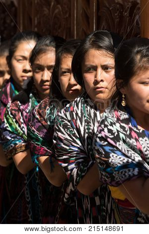 March 25, 2016 San Pedro la Laguna, Guatemala: mayan tzutujil women carrying a heavy float on the street of the small town during Easter holidays