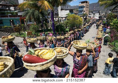 March 23, 2016 San Pedro la Laguna, Guatemala: mayan tzutujil women lining up with fruit baskets on their head to enter the local church on easter holy week celebration