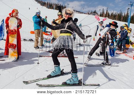 Sheregesh, Kemerovo region, Russia - April 22, 2017: Grelka Fest is a sports and entertainment activity for ski and snowboard riders in carnival costume. Woman on ski in carnival costume of dragonfly.